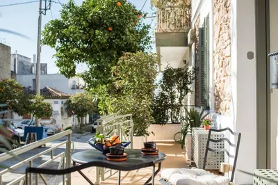 a patio with a table and chairs on a balcony at Nest in Athens