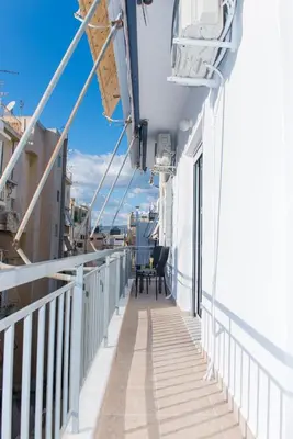 a balcony on a ship with a table and chairs at Lianos Apartments Business Class A in Piraeus