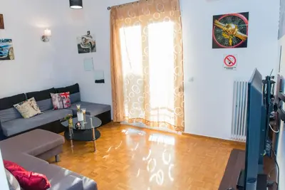 a living room with a couch and a large window at Lianos Apartments Business Class A in Piraeus