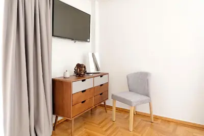 a bedroom with a dresser and a chair and a television at Acropolis Plus Penthouse in Athens