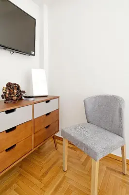 a chair sitting next to a dresser with a tv at Acropolis Plus Penthouse in Athens
