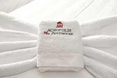 a white towel sitting on top of a bed at Acropolis Plus Penthouse in Athens