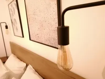 a lamp hanging over a bed in a hotel room at Athens city center cozy apartment in Athens