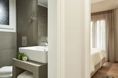 a bathroom with a white sink and a bed at Charming 1bd Apt at Concert Hall in Athens