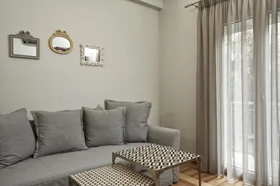 a living room with a gray couch and a table at Charming 1bd Apt at Concert Hall in Athens