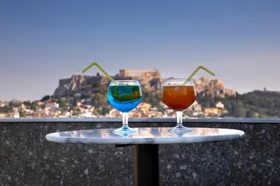 two wine glasses sitting on a tray on a balcony at The Pinnacle Athens in Athens
