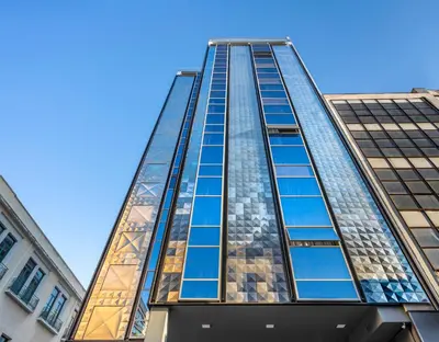 a tall glass building with a blue sky in the background at The Pinnacle Athens in Athens