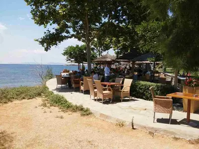 a group of people sitting at a table near the water at Athens riviera modern and elelegant flat 500 metres from VOULA beach in Athens
