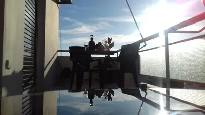 a table with a bottle of wine on a balcony at Athens riviera modern and elelegant flat 500 metres from VOULA beach in Athens