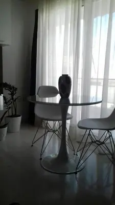 a glass table and two chairs in front of a window at Athens riviera modern and elelegant flat 500 metres from VOULA beach in Athens