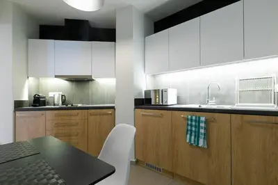 a kitchen with white cabinets and a black counter top at TONI'S 