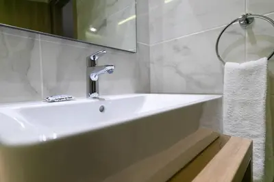 a white bathroom with a sink and a mirror at TONI'S 