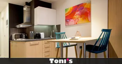 a kitchen with a table and two blue chairs at TONI'S Fashionable Studio near Presidential Garden in Athens