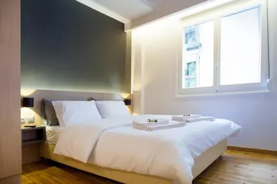 a bedroom with a large white bed with a window at TONI'S Fashionable Studio near Presidential Garden in Athens