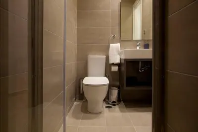 a bathroom with a toilet and a sink at TONI'S Fashionable Studio near Presidential Garden in Athens