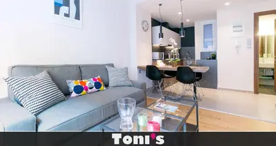 a living room with a gray couch and a kitchen at TONIS Le Petit Nicolas 1BD Apartment in Koukaki! in Athens