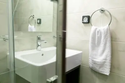 a white bathroom with a sink and a mirror at TONIS Le Petit Nicolas 1BD Apartment in Koukaki! in Athens