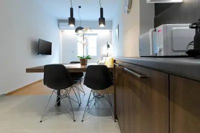 a kitchen with a table with chairs and a microwave at TONIS Le Petit Nicolas 1BD Apartment in Koukaki! in Athens