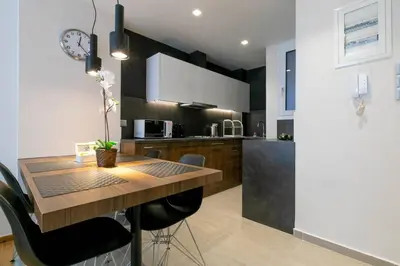 a kitchen with a wooden table and chairs at TONIS Le Petit Nicolas 1BD Apartment in Koukaki! in Athens