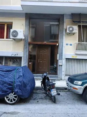 a motorcycle parked in front of a building with a tarp on it at TONIS Le Petit Nicolas 1BD Apartment in Koukaki! in Athens