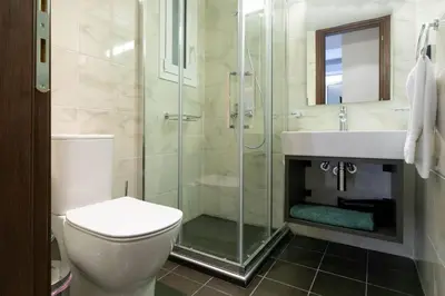 a bathroom with a shower and a toilet and a sink at TONIS Le Petit Nicolas 1BD Apartment in Koukaki! in Athens