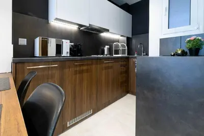 a kitchen with wooden cabinets and a counter top at TONIS Le Petit Nicolas 1BD Apartment in Koukaki! in Athens