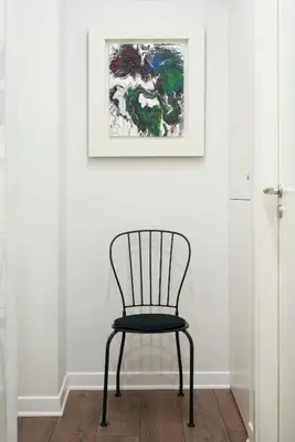 a black chair in a room with a picture on the wall at Valaoritou Boutique Apartment,Kolonaki in Athens