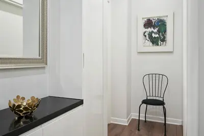 a black chair in a white room with a table at Valaoritou Boutique Apartment,Kolonaki in Athens