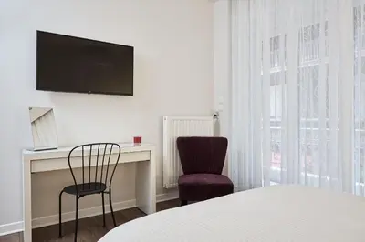 a bedroom with a bed and a desk and a tv at Valaoritou Boutique Apartment,Kolonaki in Athens