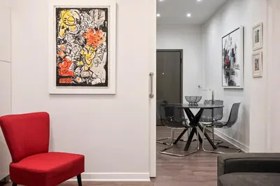 a living room with a red chair and a table at Valaoritou Boutique Apartment,Kolonaki in Athens
