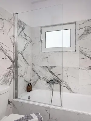 a bathroom with a bath tub and a window at Secret Aktis by BluPine in Athens