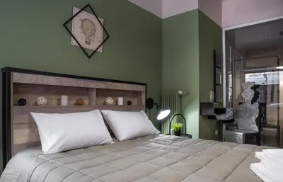 a bedroom with a large bed with green walls at Autonomous house in the heart of Plaka in Athens