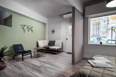 a bedroom with a bed and a chair and a mirror at Autonomous house in the heart of Plaka in Athens