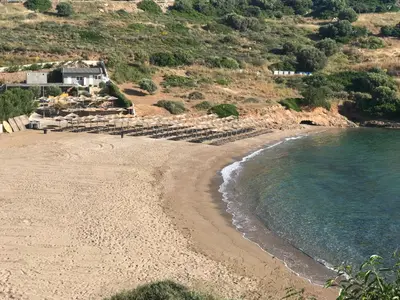 a sandy beach with a house and the ocean at MOTEL KATERINA in Keratea