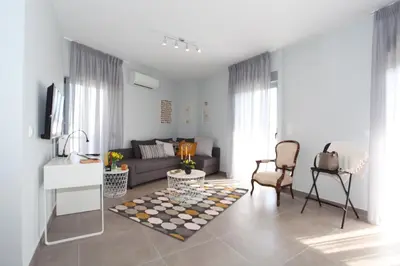 a living room with a couch and a table at Edem Beach Apartment with Sea View by Athenian Homes in Athens