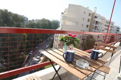 a wooden table with a vase of flowers on a balcony at Edem Beach Apartment with Sea View by Athenian Homes in Athens
