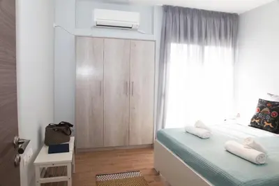 a bedroom with a bed with a air conditioner on it at Edem Beach Apartment with Sea View by Athenian Homes in Athens
