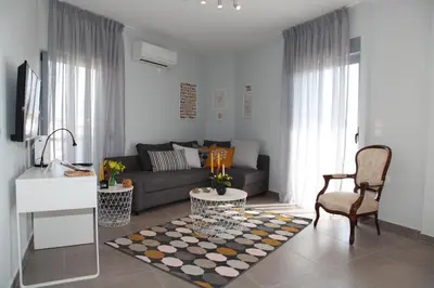 a living room with a couch and a table at Edem Beach Apartment with Sea View by Athenian Homes in Athens