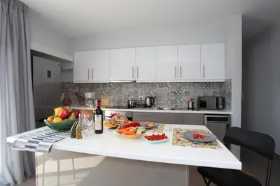a kitchen with a table with fruits and vegetables on it at Edem Beach Apartment with Sea View by Athenian Homes in Athens