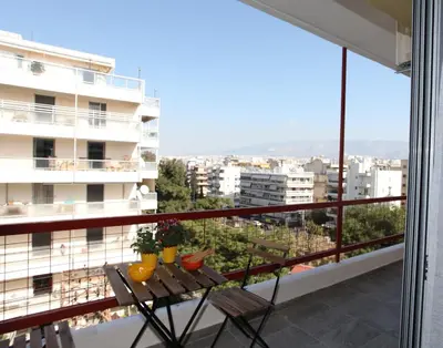 a balcony with a table and a view of a city at Edem Beach Apartment with Mountain View by Athenian Homes in Athens