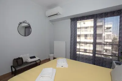 a room with a yellow table and a window at Edem Beach Apartment with Mountain View by Athenian Homes in Athens