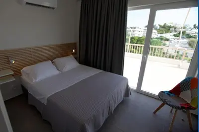 a bedroom with a bed and a large window at Seaside Renovated Top Floor Apartment in Saronida