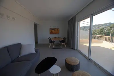 a living room with a couch and a table at Seaside Renovated Top Floor Apartment in Saronida