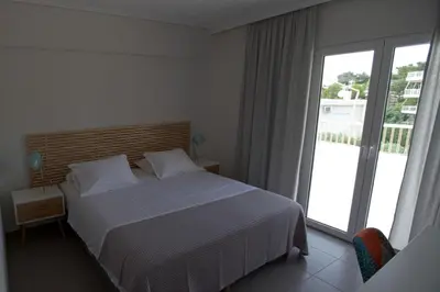a bedroom with a bed and a large window at Seaside Renovated Top Floor Apartment in Saronida