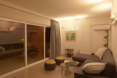a living room with a couch and a table at Seaside Renovated Top Floor Apartment in Saronida