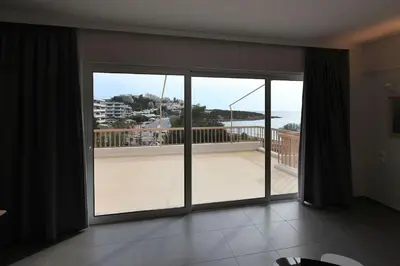 a room with a large window with a view of a balcony at Seaside Renovated Top Floor Apartment in Saronida