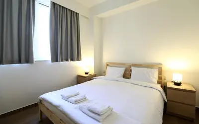 a bedroom with a white bed with towels on it at MADONAS HOUSE PSIRI in Athens