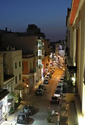 a city street at night with cars parked on the street at MADONAS HOUSE PSIRI in Athens