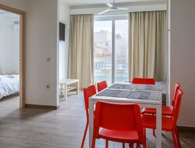 a dining room with a table and red chairs at MADONAS HOUSE PSIRI in Athens