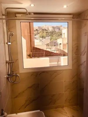 a bathroom with a window with a view of a building at Metis Athens Suites in Athens